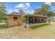 Rear exterior view showing the enclosed back patio with a view of the home's backyard at 16405 Se 90Th Ct, Summerfield, FL 34491