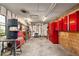 Spacious garage featuring red storage cabinets, pegboard, tool bench, and work equipment at 16405 Se 90Th Ct, Summerfield, FL 34491