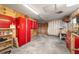 Garage with red cabinets, pegboard, workbench and equipment; ample storage and workspace at 16405 Se 90Th Ct, Summerfield, FL 34491