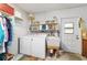 Laundry room with washer, dryer, sink, storage shelves, and access to the outdoors at 16405 Se 90Th Ct, Summerfield, FL 34491