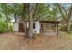 A storage shed with a covered carport-style area for storing firewood at 16405 Se 90Th Ct, Summerfield, FL 34491