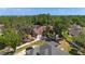 Stunning aerial view of a home with a terracotta-tiled roof surrounded by lush greenery and mature trees at 1718 Sw 27Th St, Ocala, FL 34471