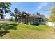 Wide shot of the home's rear exterior showcasing stone columns and a spacious green backyard at 1718 Sw 27Th St, Ocala, FL 34471