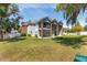 Expansive backyard view with a two-story home featuring stone columns and a charming second-story balcony at 1718 Sw 27Th St, Ocala, FL 34471