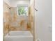 Bathroom featuring shower over tub, tiled surround, bronze fixtures, and a window at 1718 Sw 27Th St, Ocala, FL 34471