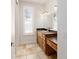 Bathroom featuring tiled floors, natural light from a window, and wooden cabinets at 1718 Sw 27Th St, Ocala, FL 34471