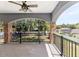 Covered patio with ceiling fan, stone columns, black metal railings, and a view of the spacious backyard at 1718 Sw 27Th St, Ocala, FL 34471