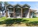 Rear exterior view highlighting the home's columns, second-story balcony, and large windows overlooking the yard at 1718 Sw 27Th St, Ocala, FL 34471