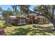 Home featuring lush landscaping, brick accents, mature trees, and a circular driveway at 1718 Sw 27Th St, Ocala, FL 34471