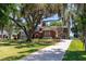 Beautiful home featuring a long driveway, mature trees draped with Spanish moss, and well-manicured lawn at 1718 Sw 27Th St, Ocala, FL 34471
