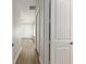 Hallway with wood floors and white trim, showcasing a door and an open space at 1718 Sw 27Th St, Ocala, FL 34471