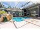 Large screened-in pool area with waterfall feature, integrated spa, and ample space for entertaining at 1718 Sw 27Th St, Ocala, FL 34471