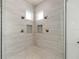 Spacious glass enclosed shower with bench, dual shower heads, and tile surround at 1718 Sw 27Th St, Ocala, FL 34471