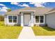 Inviting entryway featuring a white front door, manicured landscaping, and modern architectural details at 2329 Sw 143Rd Ct, Ocala, FL 34481