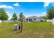 Large backyard featuring lush greenery, a white fence, and a glimpse of the home's exterior at 27 Juniper Dr, Ocala, FL 34480