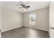 Bright bedroom featuring wood-look flooring, a ceiling fan, and a sunny window at 27 Juniper Dr, Ocala, FL 34480
