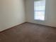 Bedroom with neutral carpet, window, and convenient electrical outlets at 2730 Sw 173Rd Place Rd, Ocala, FL 34473