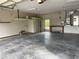 Clean garage with painted walls, concrete floor, workbench, and shelving for organized storage and workspace at 2730 Sw 173Rd Place Rd, Ocala, FL 34473