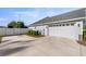 Spacious three-car garage with a long driveway and mature landscaping at 4020 Se 23Rd St, Ocala, FL 34471