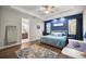 Stylish main bedroom with blue accent wall, tray ceiling, and access to the bathroom at 4020 Se 23Rd St, Ocala, FL 34471