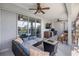 Covered outdoor patio space featuring a comfortable seating area, a ceiling fan, a TV and a view of the pool at 4020 Se 23Rd St, Ocala, FL 34471