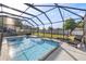 Beautiful screened-in pool with a sun shelf and a lounge chair, offering a private backyard retreat at 4020 Se 23Rd St, Ocala, FL 34471