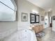 Bright bathroom featuring a large tub, dual sink vanity, tiled floors, and natural lighting at 4033 Ne 15Th Court Rd, Ocala, FL 34479