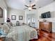 Spacious bedroom featuring a ceiling fan, French doors, wood flooring, and a comfortable bed at 4033 Ne 15Th Court Rd, Ocala, FL 34479