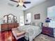 Bright bedroom with a ceiling fan, wood floors, comfortable bed, vanity, and natural lighting at 4033 Ne 15Th Court Rd, Ocala, FL 34479