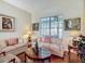 Cozy living room featuring hardwood floors, neutral-toned furniture, and natural light from a large window at 4033 Ne 15Th Court Rd, Ocala, FL 34479