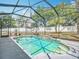 Beautiful screened-in pool with lush landscaping offering a refreshing oasis for relaxation and recreation at 4033 Ne 15Th Court Rd, Ocala, FL 34479