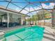 Tranquil screened-in pool, patio, and landscaped backyard with a white fence for ultimate privacy and leisure at 4033 Ne 15Th Court Rd, Ocala, FL 34479