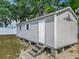 Exterior view of the shed, with a white door and white trimmed windows at 4033 Ne 15Th Court Rd, Ocala, FL 34479
