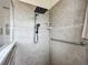 Tiled shower featuring a large shower head, handheld sprayer, and grab bar at 4033 Ne 15Th Court Rd, Ocala, FL 34479