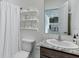 Charming bathroom with granite countertop, decorative shelves and patterned shower curtain at 4188 Sw 53Rd Lane Rd, Ocala, FL 34474