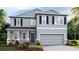 Two-story home with blue shutters, a gray exterior, a two-car garage, and landscaped front yard at 4188 Sw 53Rd Lane Rd, Ocala, FL 34474