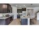 Bright kitchen featuring dark cabinets, stainless steel appliances, an island with bar seating, and wood-look tile floors at 4188 Sw 53Rd Lane Rd, Ocala, FL 34474