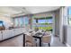 Open dining area with a dark table, modern chairs, elegant table settings, and scenic views through large windows and a sliding glass door at 4196 Sw 53Rd Lane Rd, Ocala, FL 34474