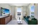 Stylish living room features a green velvet sofa, modern glass table, and large windows at 4196 Sw 53Rd Lane Rd, Ocala, FL 34474