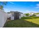 View of the backyard with green grass, white fence and small shed at 4398 Ne 29Th St, Ocala, FL 34470