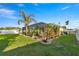 Landscaped backyard with green lawn, palm trees, and screened in patio at 4398 Ne 29Th St, Ocala, FL 34470