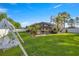View of the backyard with green lawn, mature trees, and screened in patio at 4398 Ne 29Th St, Ocala, FL 34470