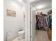 Bright half bathroom with tile floor and framed art along with a view into a walk-in closet at 4398 Ne 29Th St, Ocala, FL 34470