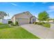 Exterior view of the home featuring an attached two-car garage and landscaped yard at 4398 Ne 29Th St, Ocala, FL 34470