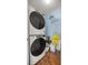 Stackable white washer and dryer in laundry room with vinyl floor and 