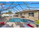 Enclosed pool with a waterfall feature, outdoor seating, and lush landscaping at 4398 Ne 29Th St, Ocala, FL 34470