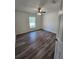 Cozy bedroom featuring a ceiling fan, wood-look floors, and natural light at 441 Nw Buena Vista Rd, Dunnellon, FL 34431