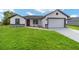 Charming single-story home featuring a well-manicured lawn and a two-car garage at 5 Willow Trl, Ocala, FL 34472