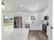 Modern kitchen boasts white cabinets, stainless steel appliances, and a quartz countertop island at 5 Willow Trl, Ocala, FL 34472