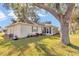 The backyard features a grill, screened-in porch, lush lawn, and mature trees at 6127 Sw 84Th Place Rd, Ocala, FL 34476